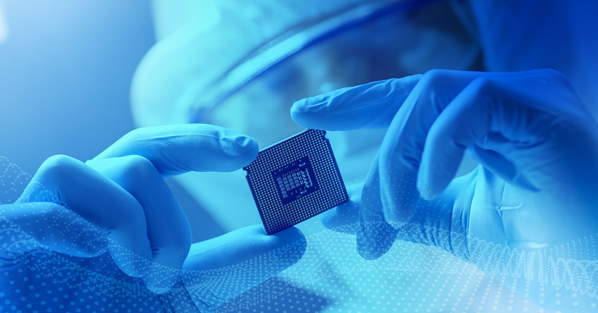 A factory worker inspects a computer chip